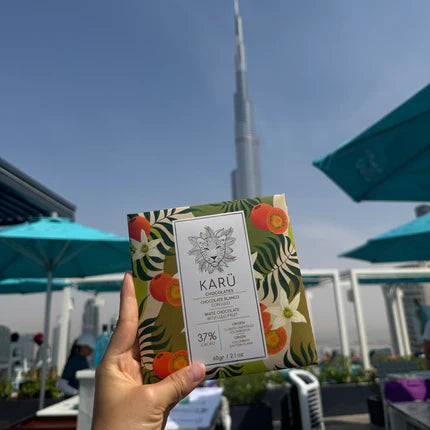 Hand holding a Karu chocolate bar with a cityscape in the background